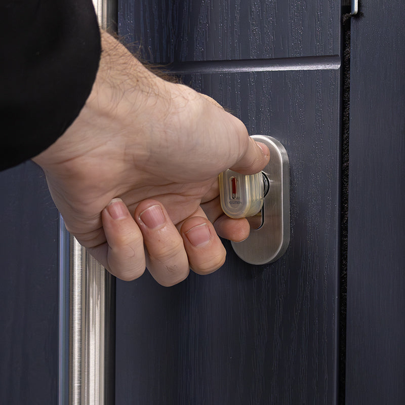 image of a hand turning a thumbturn cylinder from the inside of a property